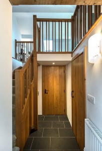 Hallway with door to garage and shower room on right. Stairs to mezzanine on left